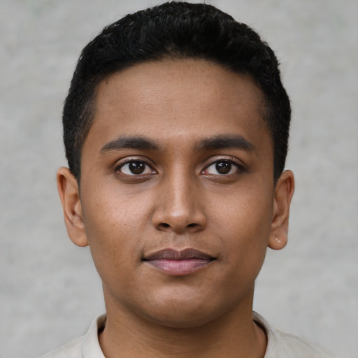 Joyful latino young-adult male with short  black hair and brown eyes