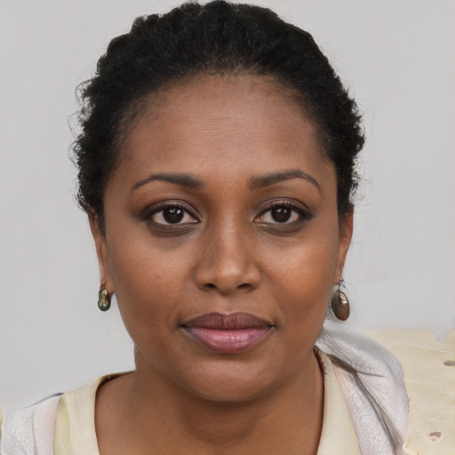 Joyful black young-adult female with short  brown hair and brown eyes