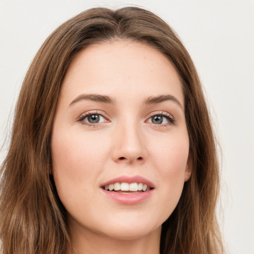 Joyful white young-adult female with long  brown hair and green eyes