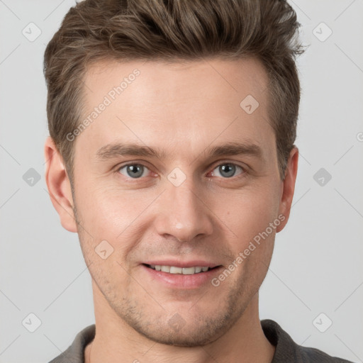 Joyful white young-adult male with short  brown hair and grey eyes