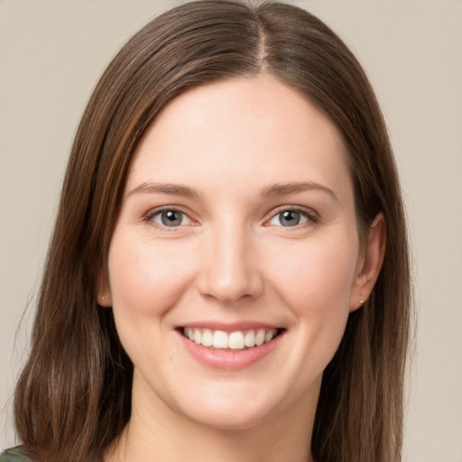 Joyful white young-adult female with long  brown hair and grey eyes