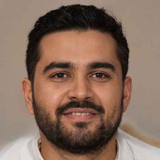 Joyful latino young-adult male with short  black hair and brown eyes