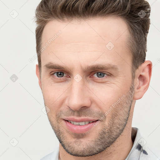 Joyful white adult male with short  brown hair and brown eyes