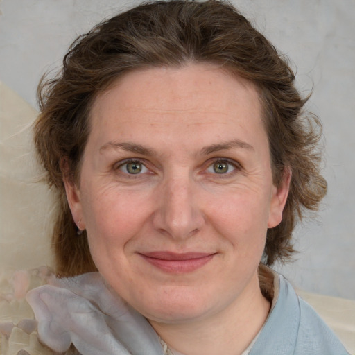 Joyful white adult female with medium  brown hair and blue eyes