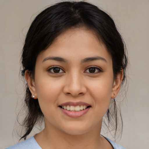 Joyful latino young-adult female with medium  brown hair and brown eyes