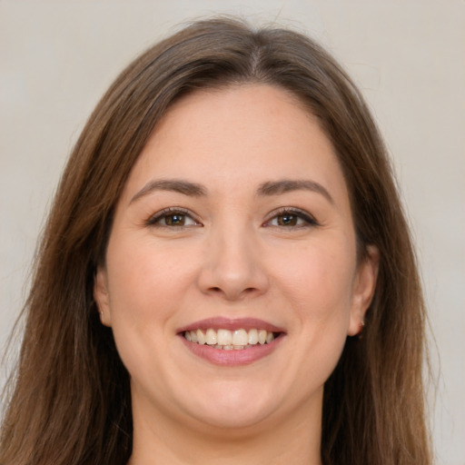 Joyful white young-adult female with long  brown hair and brown eyes