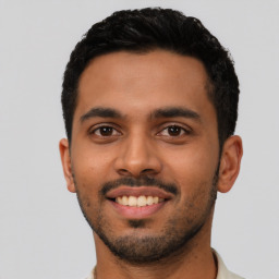 Joyful latino young-adult male with short  black hair and brown eyes