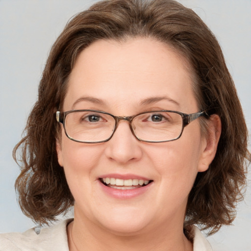 Joyful white adult female with medium  brown hair and blue eyes