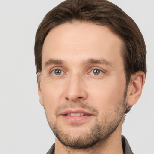 Joyful white young-adult male with short  brown hair and grey eyes