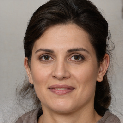 Joyful white adult female with medium  brown hair and brown eyes