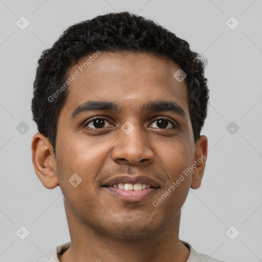 Joyful black young-adult male with short  brown hair and brown eyes