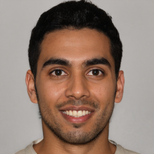 Joyful latino young-adult male with short  black hair and brown eyes