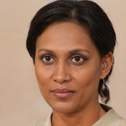 Joyful black adult female with medium  brown hair and brown eyes