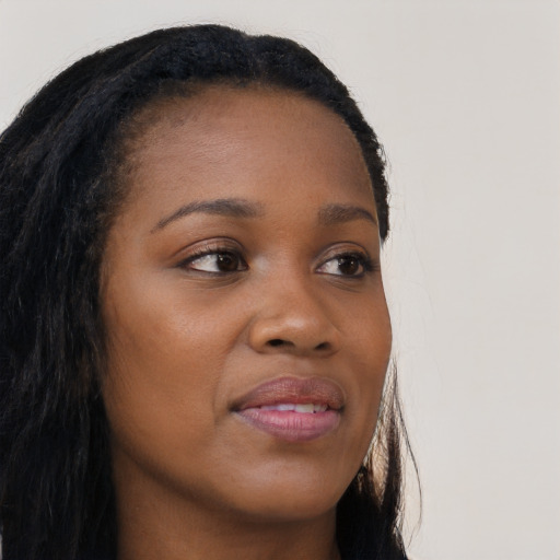 Joyful black young-adult female with long  brown hair and brown eyes