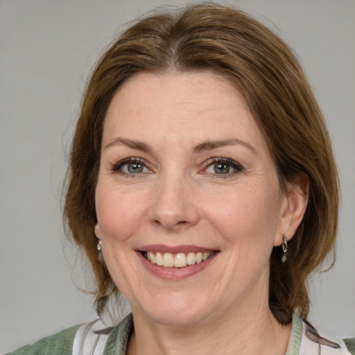 Joyful white adult female with medium  brown hair and blue eyes