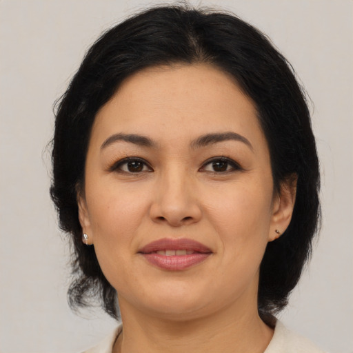 Joyful asian adult female with medium  brown hair and brown eyes