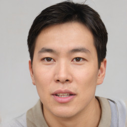 Joyful asian young-adult male with short  brown hair and brown eyes