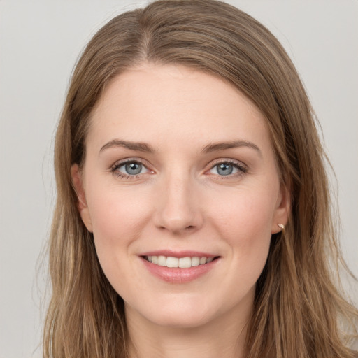 Joyful white young-adult female with long  brown hair and grey eyes