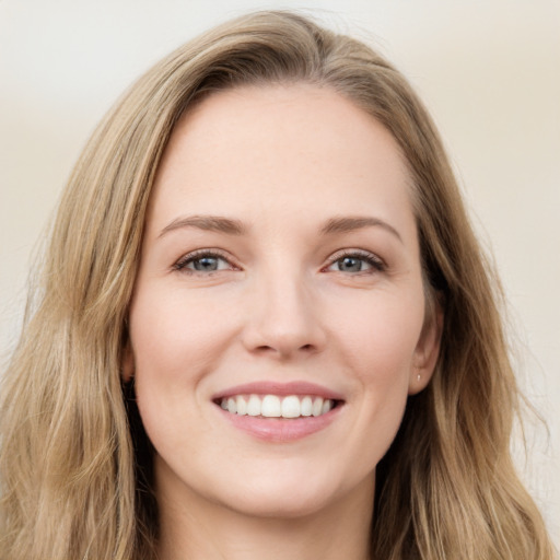 Joyful white young-adult female with long  brown hair and green eyes