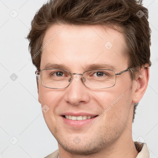 Joyful white adult male with short  brown hair and grey eyes