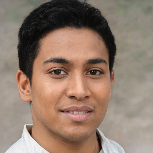 Joyful latino young-adult male with short  brown hair and brown eyes