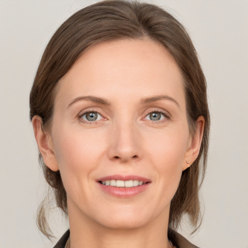 Joyful white adult female with medium  brown hair and grey eyes