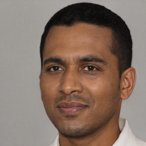 Joyful black young-adult male with short  black hair and brown eyes