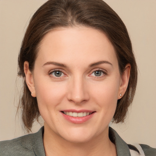 Joyful white young-adult female with medium  brown hair and green eyes