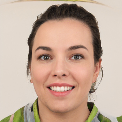 Joyful white young-adult female with medium  brown hair and green eyes