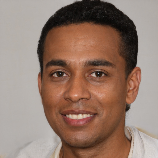 Joyful black young-adult male with short  black hair and brown eyes