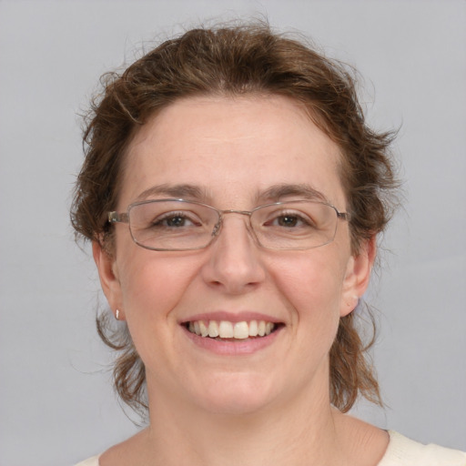 Joyful white adult female with medium  brown hair and green eyes