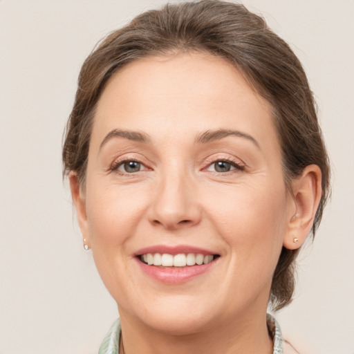 Joyful white young-adult female with medium  brown hair and grey eyes