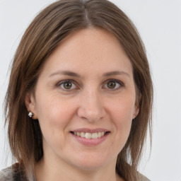 Joyful white adult female with medium  brown hair and grey eyes