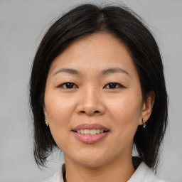 Joyful asian adult female with medium  brown hair and brown eyes