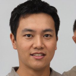 Joyful asian young-adult male with short  black hair and brown eyes