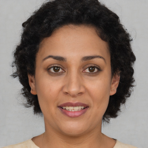 Joyful latino adult female with short  brown hair and brown eyes