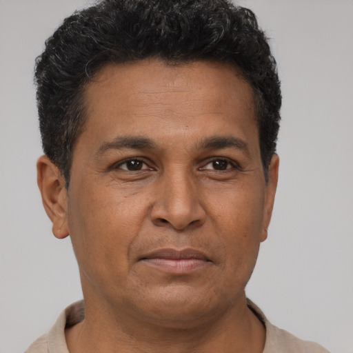 Joyful latino young-adult male with short  brown hair and brown eyes