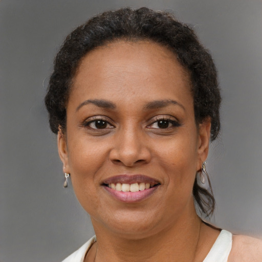 Joyful black adult female with short  brown hair and brown eyes