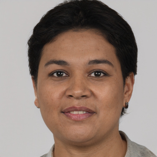 Joyful latino young-adult female with short  black hair and brown eyes