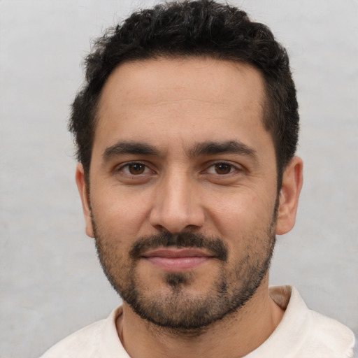 Joyful white young-adult male with short  black hair and brown eyes