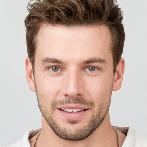 Joyful white young-adult male with short  brown hair and grey eyes