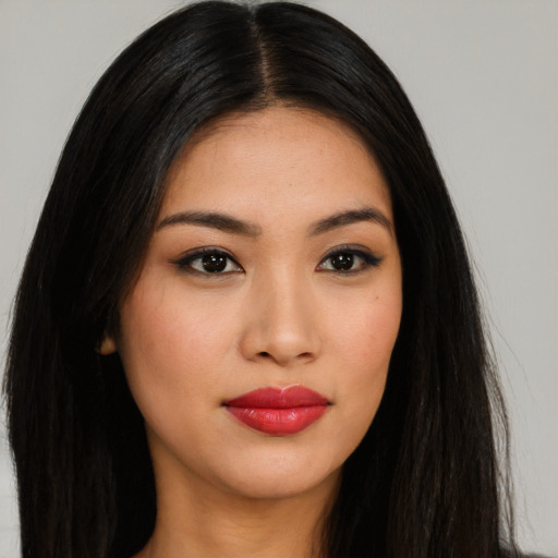 Joyful latino young-adult female with long  black hair and brown eyes