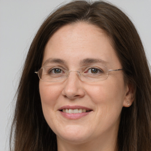 Joyful white adult female with long  brown hair and grey eyes