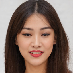 Joyful asian young-adult female with long  brown hair and brown eyes