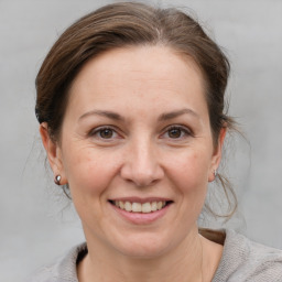 Joyful white adult female with medium  brown hair and grey eyes