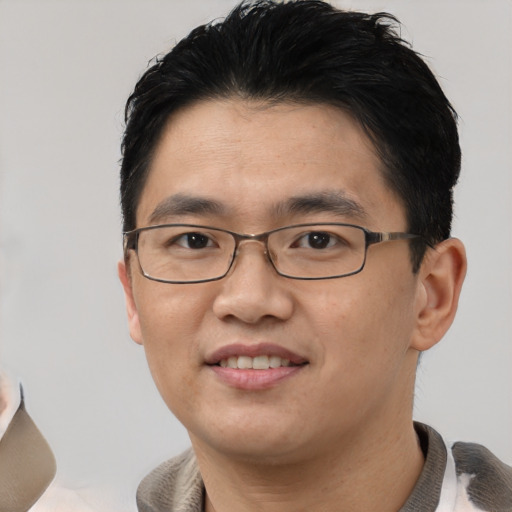 Joyful asian young-adult male with short  black hair and brown eyes
