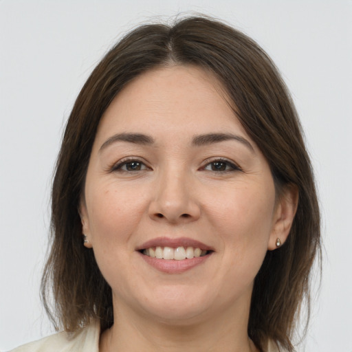 Joyful white adult female with medium  brown hair and brown eyes