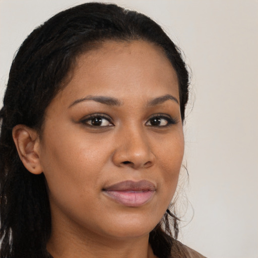 Joyful black young-adult female with long  brown hair and brown eyes