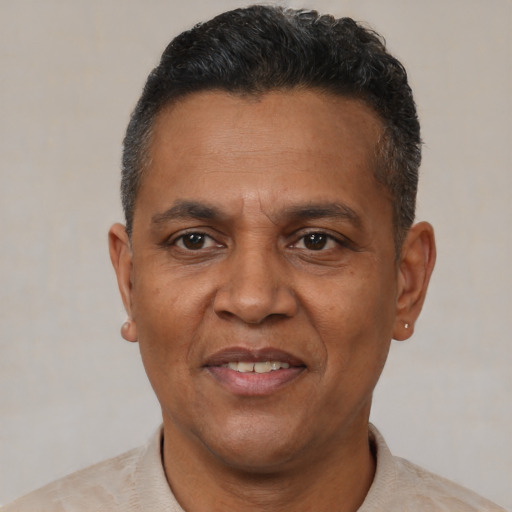 Joyful black adult male with short  brown hair and brown eyes