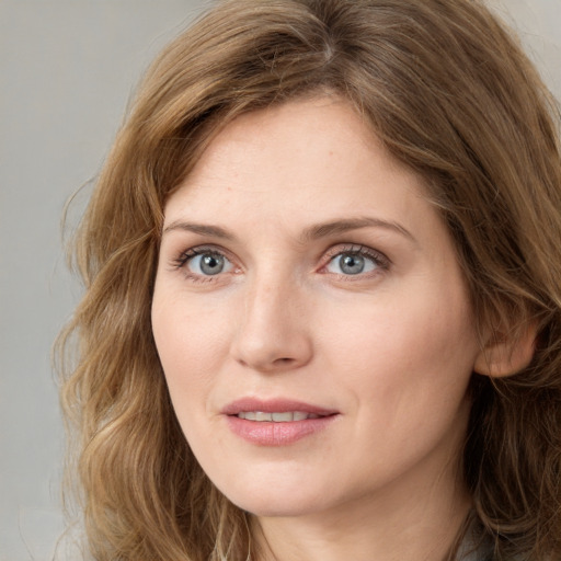 Joyful white young-adult female with long  brown hair and blue eyes